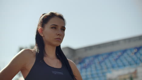 Beautiful-woman-athlete-at-the-stadium-breathing-and-preparing-to-start-the-race.-Motivation-and-tuning-for-the-race.-Concentration-and-attitude